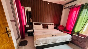 Une chambre à coucher avec un lit, une table de chevet, un miroir et une porte.