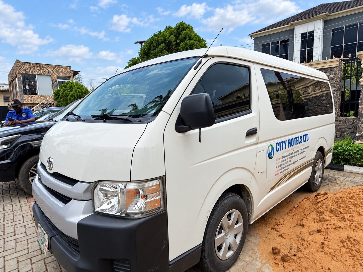 Una camioneta blanca con la leyenda 'CITY HOTELS LTD.' estacionada en un área pavimentada.