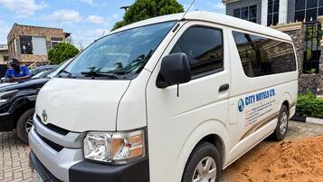 Una camioneta blanca con la leyenda 'CITY HOTELS LTD.' estacionada en un área pavimentada.