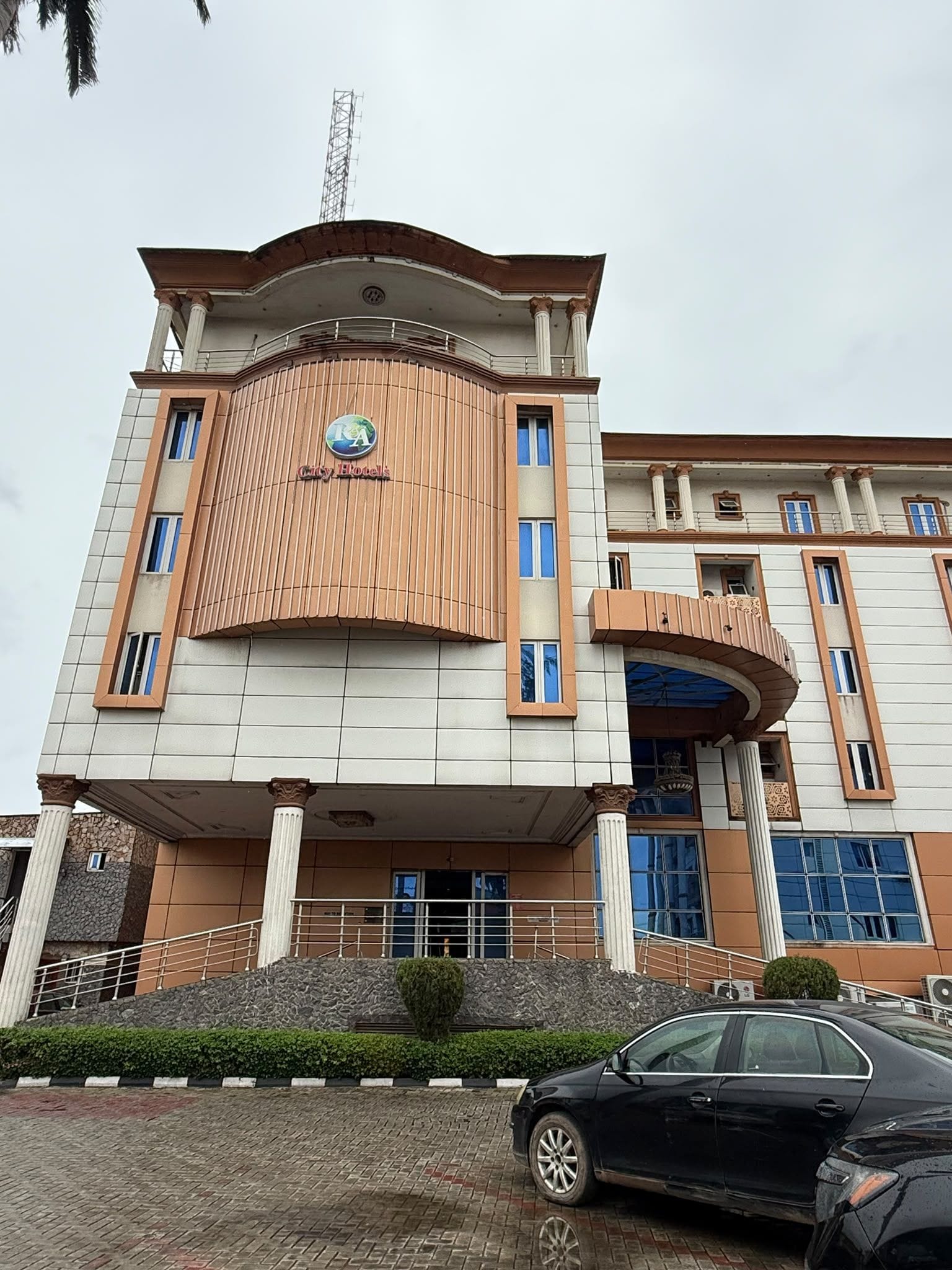 A hotel with a prominent entrance, a large logo, and a modern architectural design.