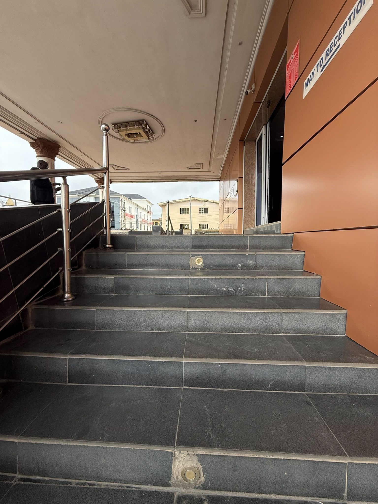 A staircase leading to an entrance with a reception sign.