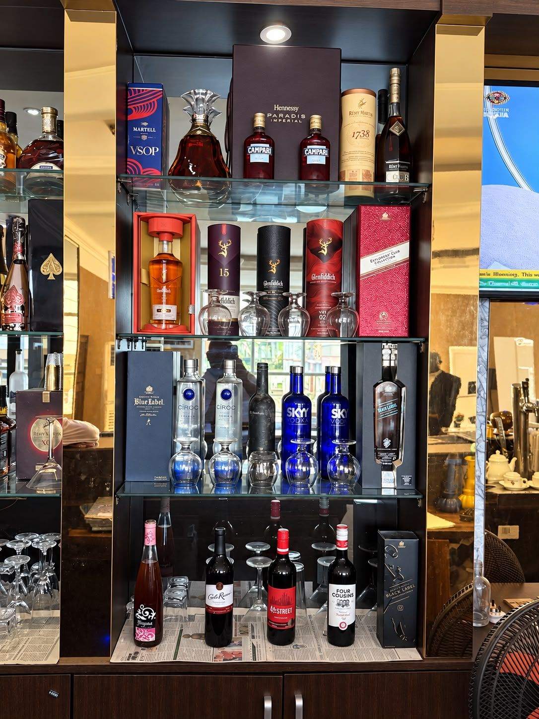 A liquor store with various bottles and boxes of alcohol on shelves.