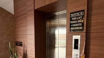 Un ascensor con un cartel que indica una capacidad máxima de 4 pasajeros.