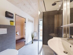 Ein modernes Badezimmer mit einer großzügigen Badewanne, einer separaten Duschkabine und einem WC.