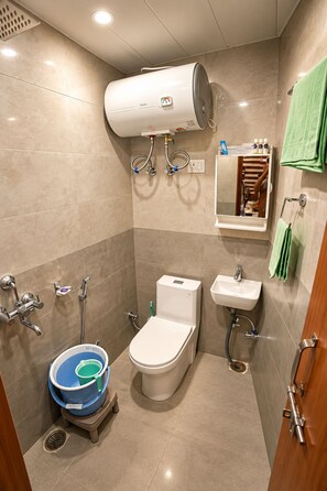 Un baño moderno con inodoro, bidé, lavamanos y zona de ducha.