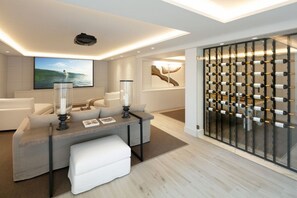 Ein modernes Wohnzimmer mit einer Couch, einem Couchtisch und einem Weinkühlschrank.