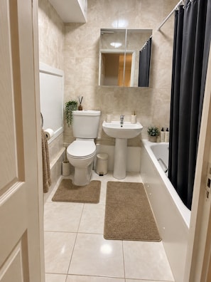 Ein Badezimmer mit Toilette, Waschbecken und Badewanne.