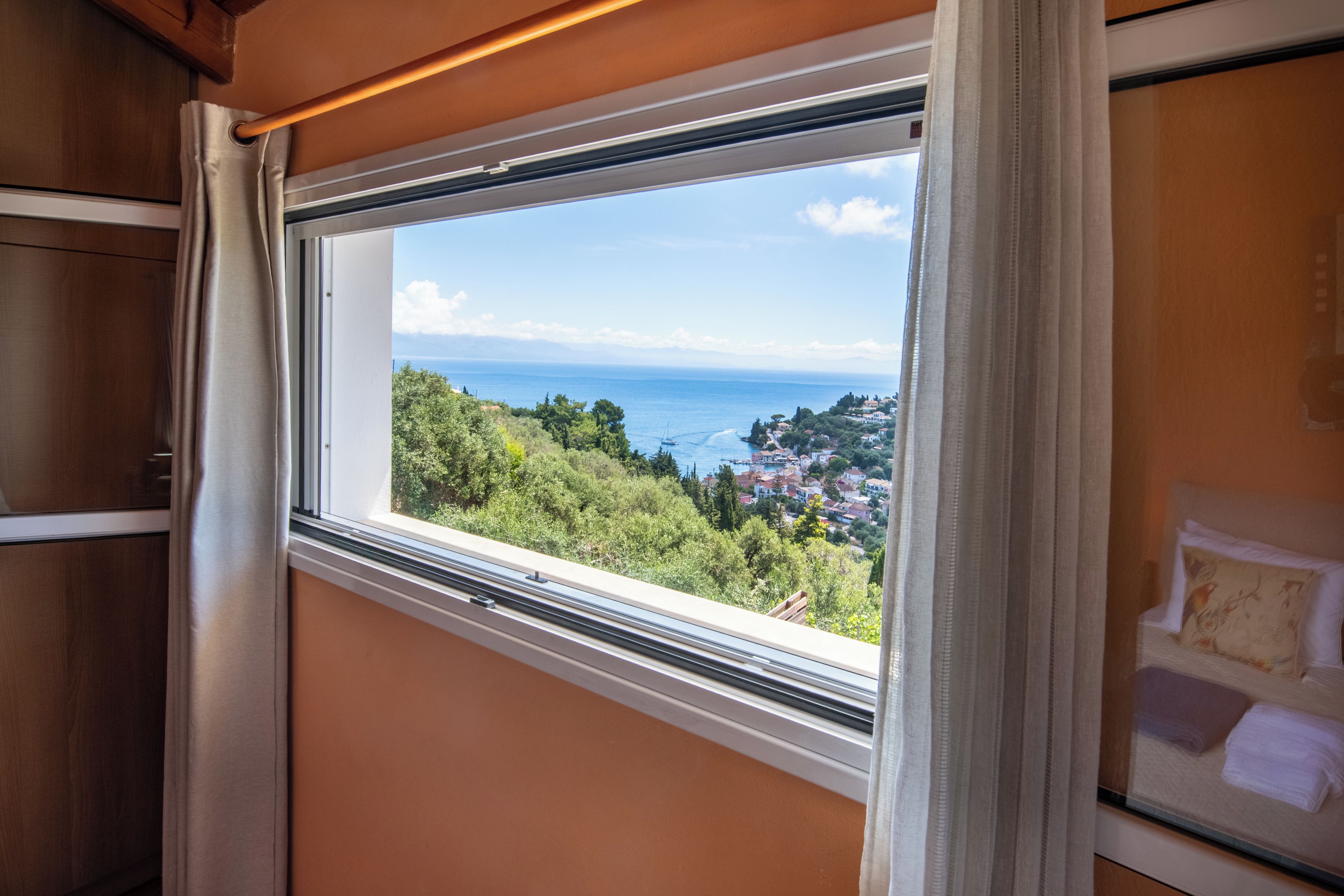 Una ventana con vistas a un pueblo costero y al mar.