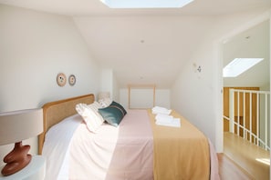 A bedroom with a bed, a bedside table, a lamp, and a view of the outside. - NEW! A Quiet Retreat by the Atlantic Coast (Encarnação)