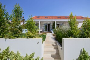 A modern house with a red-tiled roof, a covered porch, and a pathway leading to the entrance. - NEW! A Quiet Retreat by the Atlantic Coast (Encarnação)