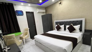 Ein Hotelzimmer mit Bett, Schreibtisch, Stuhl und Klimaanlage.