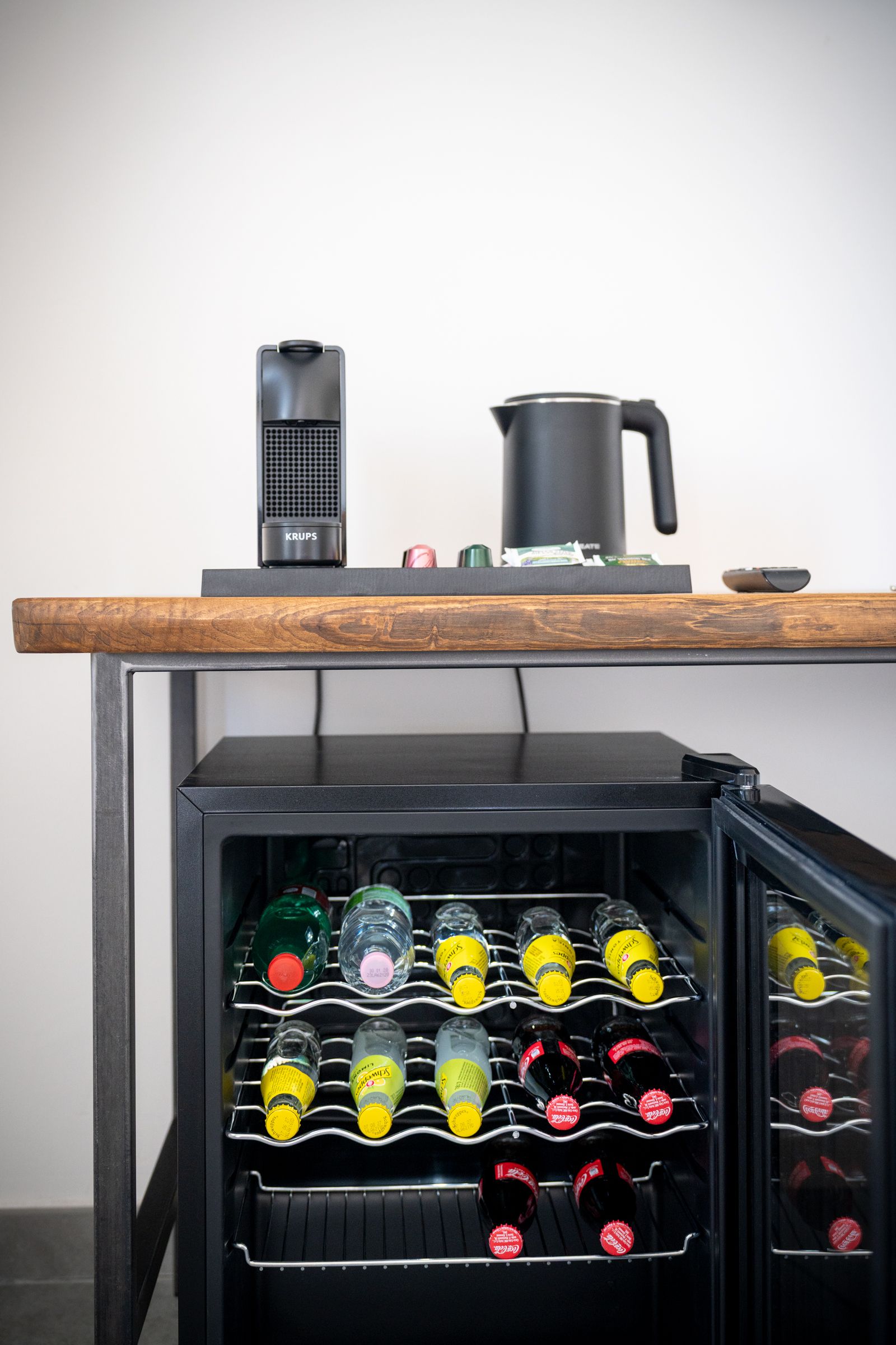 A kitchen area with a built-in wine cooler containing various bottles.