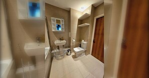 Ein modernes Badezimmer mit Badewanne, Waschbecken, Toilette und Dusche.