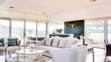 Un salon moderne avec un canapé, une table basse et une grande fenêtre.