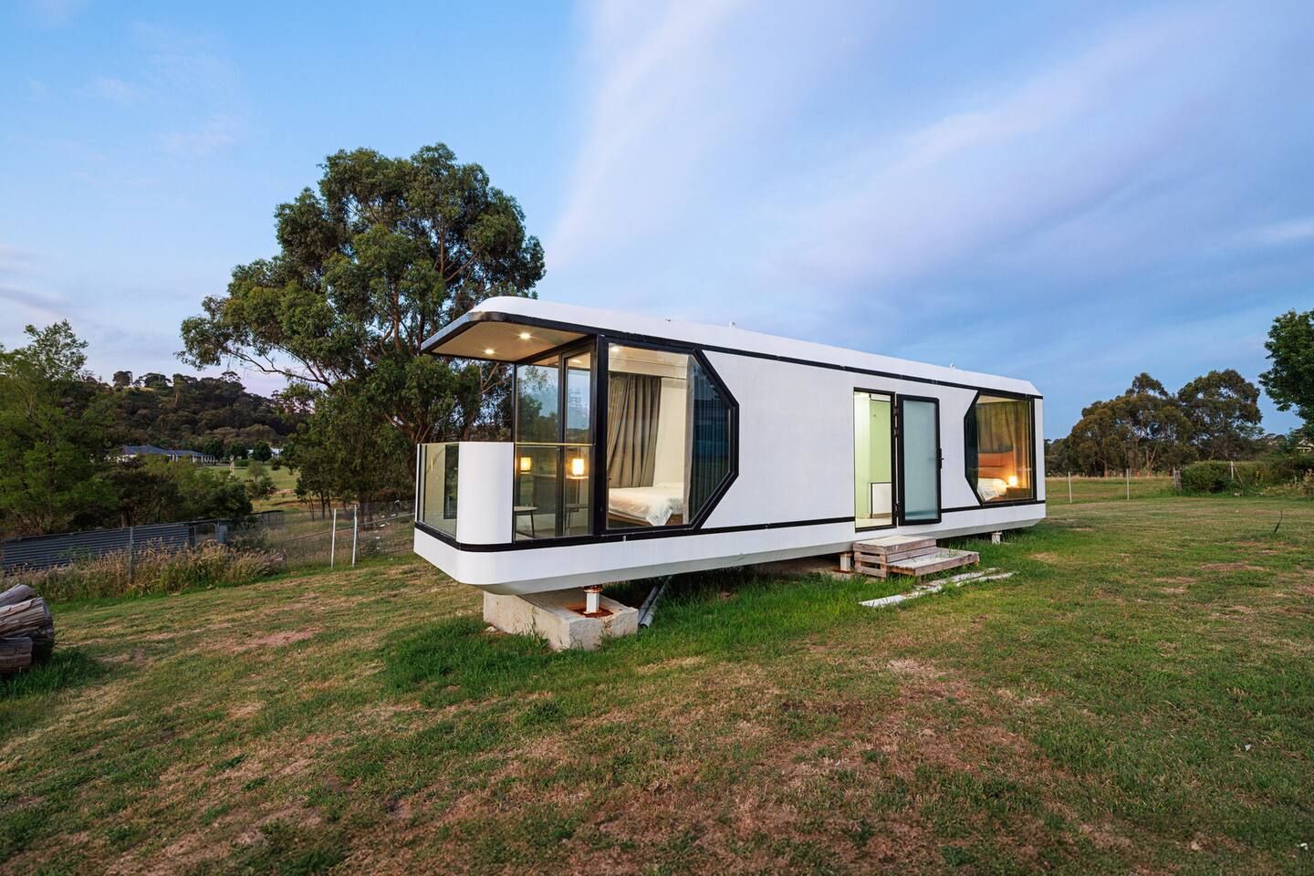 A modern, single-story mobile home with large windows, a flat roof, and a minimalist design.