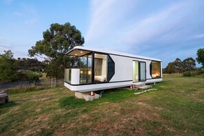 A modern, single-story mobile home with large windows, a flat roof, and a minimalist design.