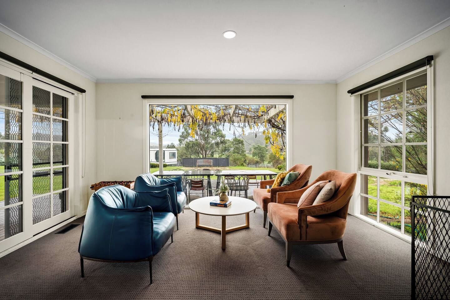 A room with a large window, a round table, and two sofas.