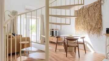 A modern interior with a spiral staircase, wooden flooring, and a dining area.