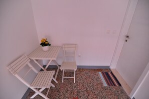 A small room with a white table and two chairs, a small potted plant, and a striped rug on a speckled floor. - A1 - luxury apartment in center, just 5 min from beach (Korčula)