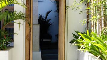 Une étroite entrée encadrée de bois, qui mène à un escalier et à un intérieur sombre.