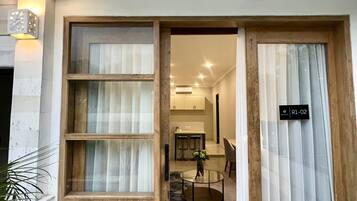 A modern interior with a dining area, a kitchen, and a staircase leading to an upper level.