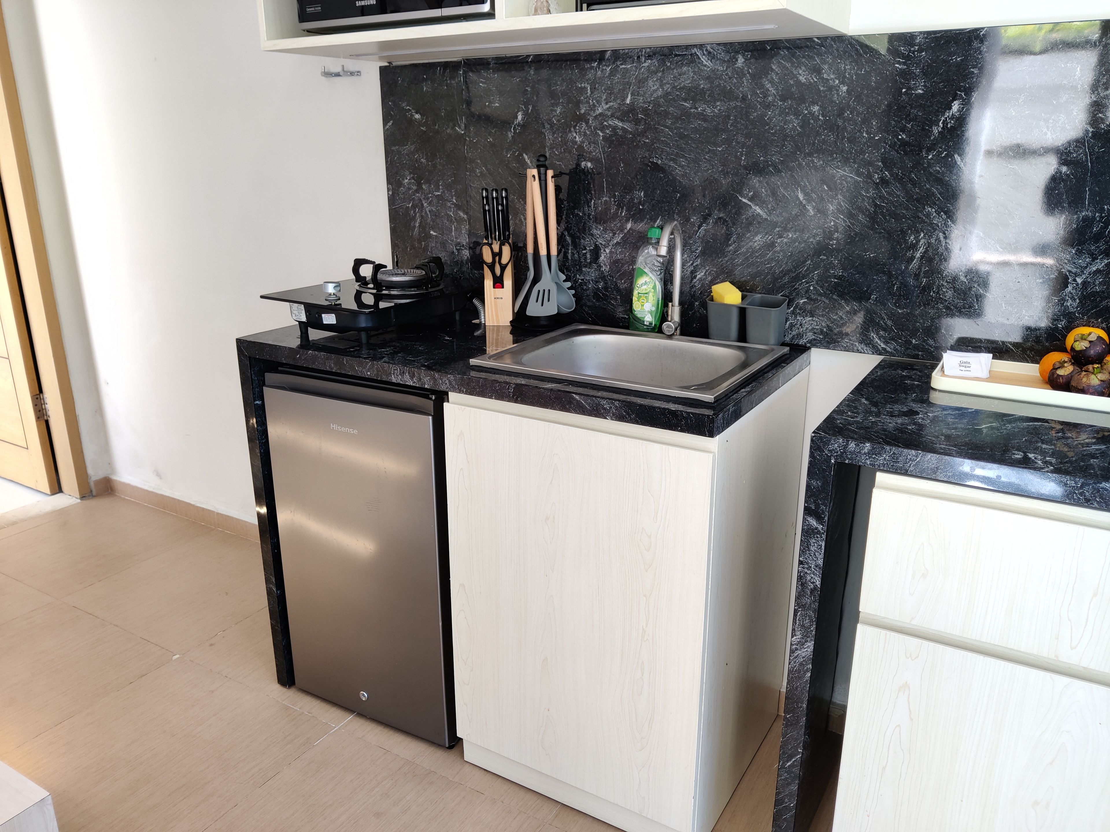 Una cocina funcional con lavavajillas incorporado, cocina a gas y pileta.
