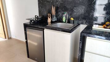 Una cocina funcional con lavavajillas incorporado, cocina a gas y pileta.
