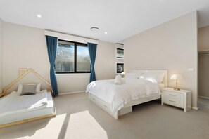 Ein Schlafzimmer mit Bett, Nachttisch und einem Fenster mit Vorhängen.