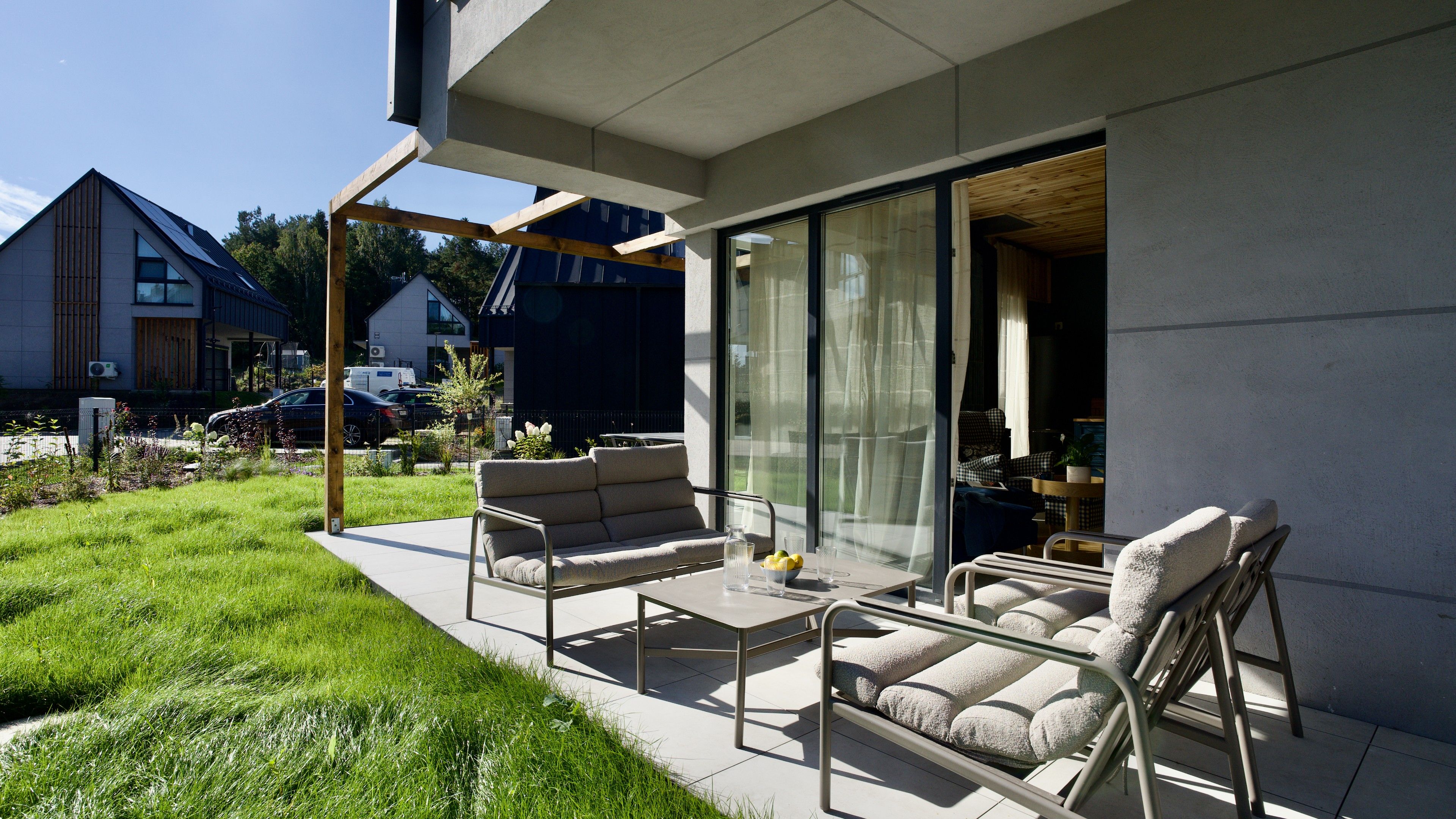 A modern outdoor patio with a sofa, chairs, and a table.