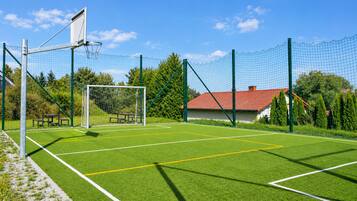 Un campo de fútbol con porterías, una red y un banco.