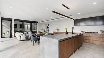 A modern kitchen with a central island, wooden cabinets, and a built-in oven.