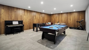 A room with a pool table, a piano, a treadmill, and a sofa. - Grand Designer 5BR Home with Pool | Balwyn (Balwyn North)