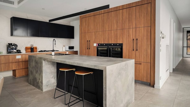 A modern kitchen with a central island, wooden cabinets, and built-in appliances. - Grand Designer 5BR Home with Pool | Balwyn (Balwyn North)