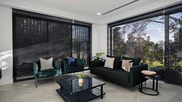 A modern living room with a sofa, two armchairs, and a coffee table.