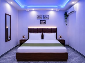 Een moderne slaapkamer met een groot bed, twee nachtkastjes, een spiegel en lijstwerken aan de muur.