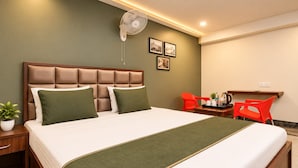 Una habitación de hotel con cama, mesita de noche y escritorio con silla.