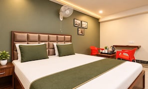 Una habitación de hotel con cama, mesita de noche y escritorio con silla.