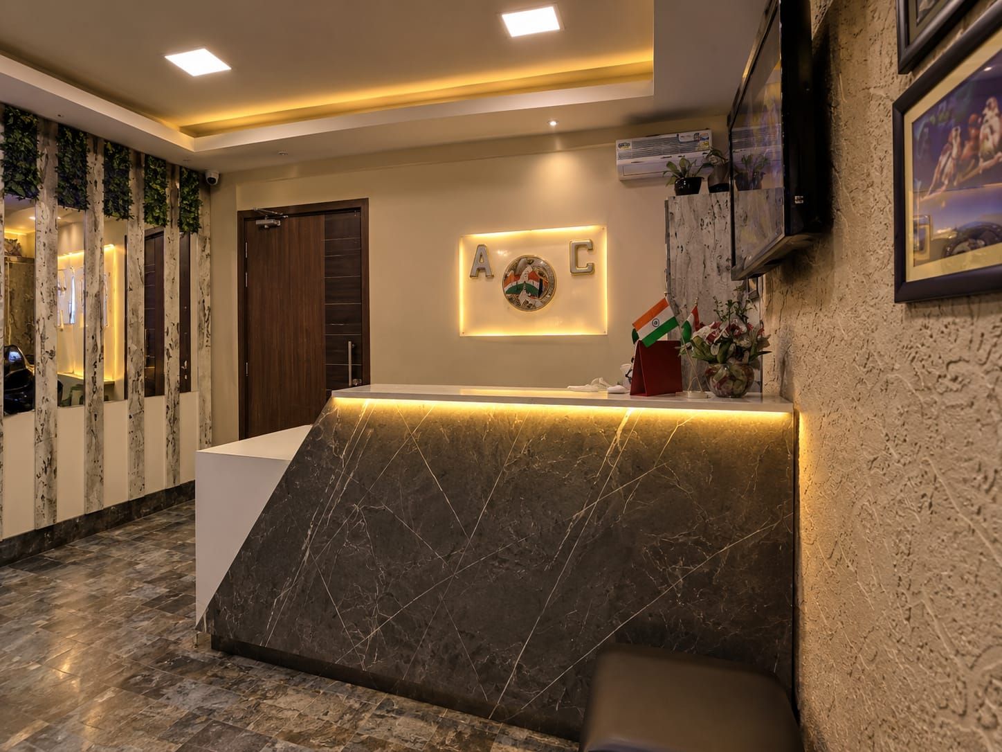 A reception area with a marble counter, a wall-mounted A/C unit, and a framed picture.