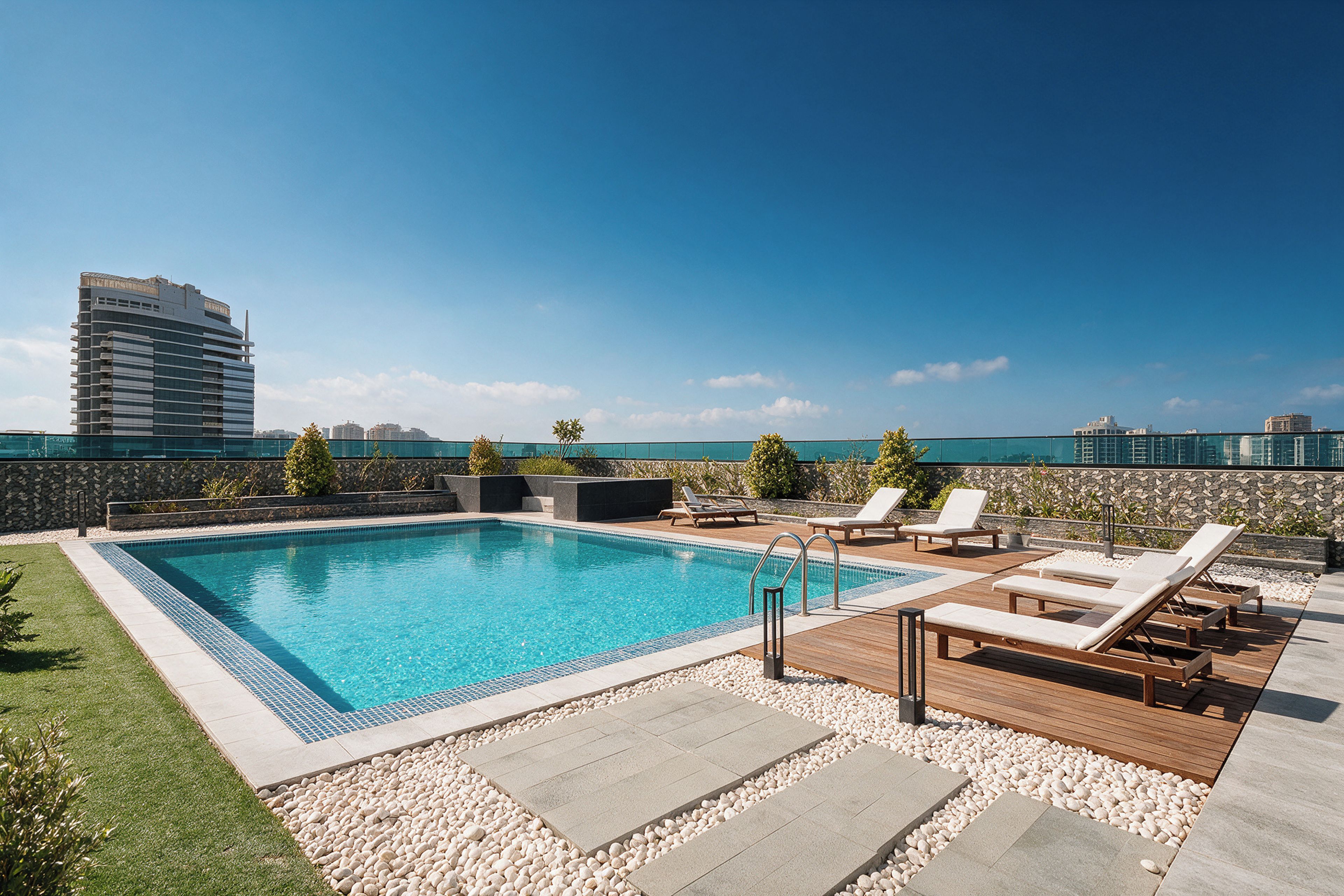 A rooftop pool with lounge chairs and a view of the city skyline.