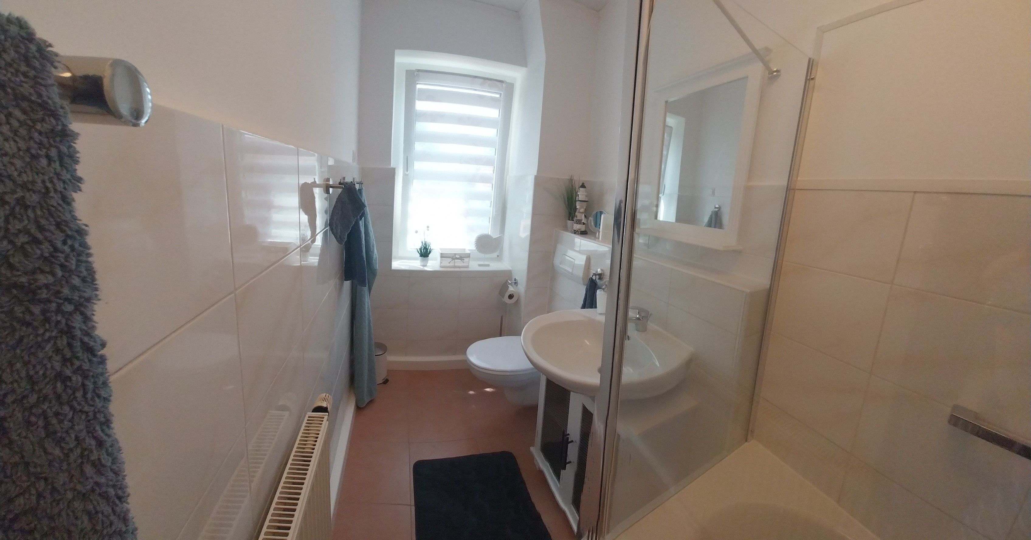 Ein Badezimmer mit Dusche, Waschbecken und Toilette.