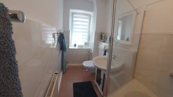 Ein Badezimmer mit Dusche, Waschbecken und Toilette.