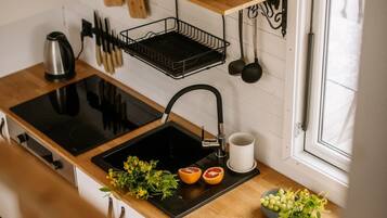 A kitchen with a black stove, a sink, and a window.
