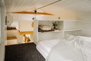 A bedroom with a bunk bed, a white wardrobe, and a small shelf with a plant. - Cosy Tiny House by the Water, Close to Nature (Gabrielnia)