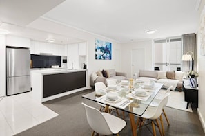 A modern apartment with a kitchen, dining area, and living room. - Suite 1108 : Spacious CBD 3 Beds +Pool, Gym & Parking (Brisbane City)