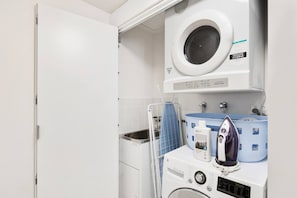 A laundry area with a washing machine, an iron, and a drying rack. - Suite 1108 : Spacious CBD 3 Beds +Pool, Gym & Parking (Brisbane City)