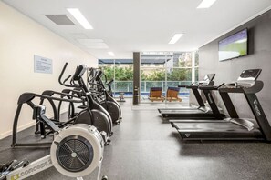 A gym with stationary bikes, treadmills, and a rowing machine. - Central Eco-Luxe 2BR, 2BTH • Pool, Gym & Parking (Brisbane City)