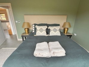 A neatly made bed with two pillows, two bedside lamps, and two folded towels. - Granfers (Penryn)