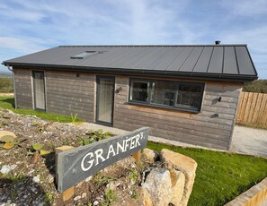A modern house with a dark roof, wooden siding, and a sign reading 'GRANFER'S' in front. - Granfers (Penryn)