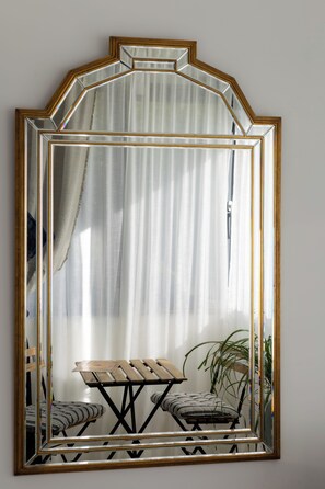 A large mirror with a geometric frame, reflecting a room with a table and chairs. - Large, modern villa consisting of 4 fully equipped, independent apartments (Saint-Paul-de-Vence)