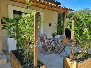 An outdoor patio with a wooden pergola, a table with chairs, and potted plants. - Large, modern villa consisting of 4 fully equipped, independent apartments (Saint-Paul-de-Vence)